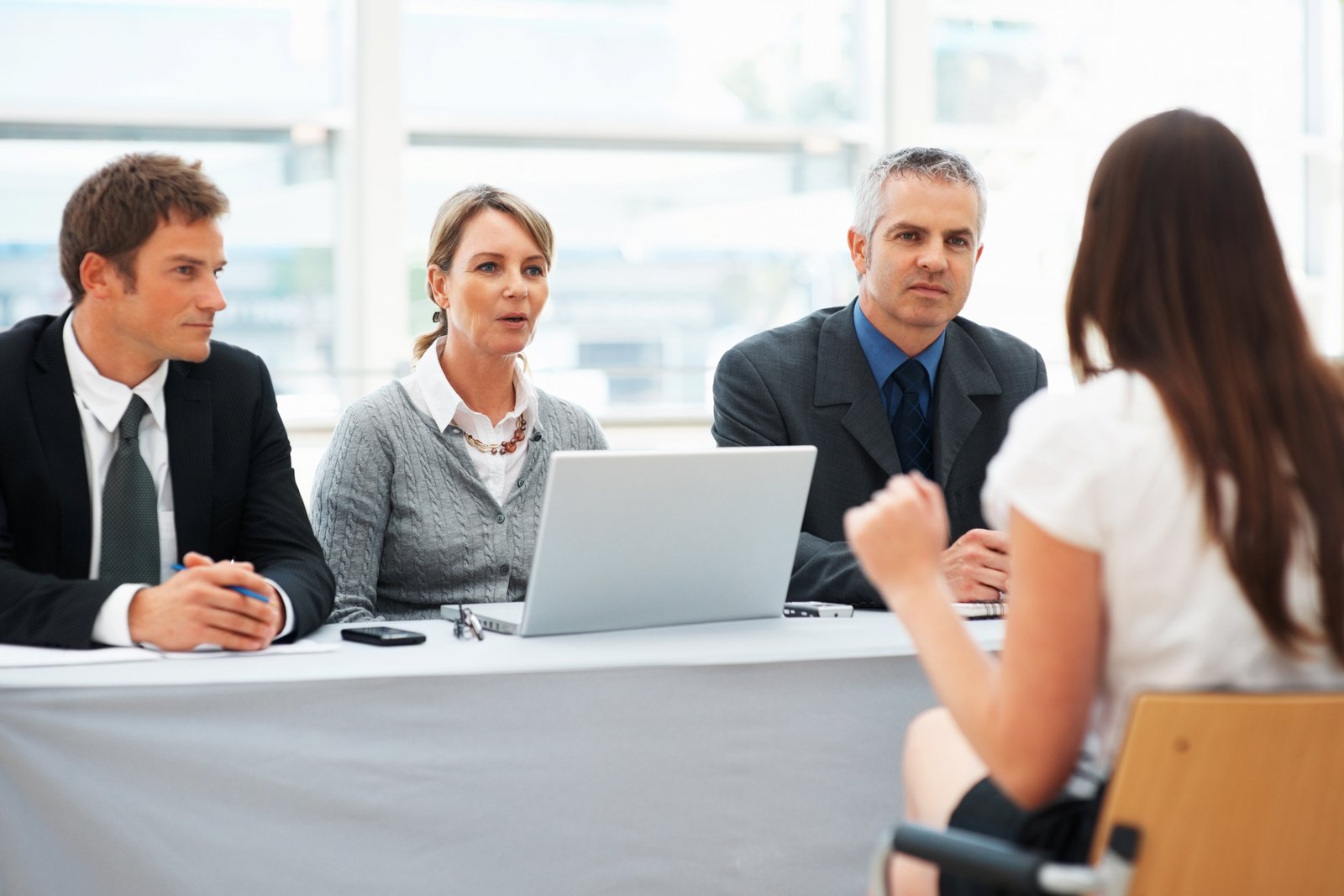 Recruitment consultants in a briefing around a laptop